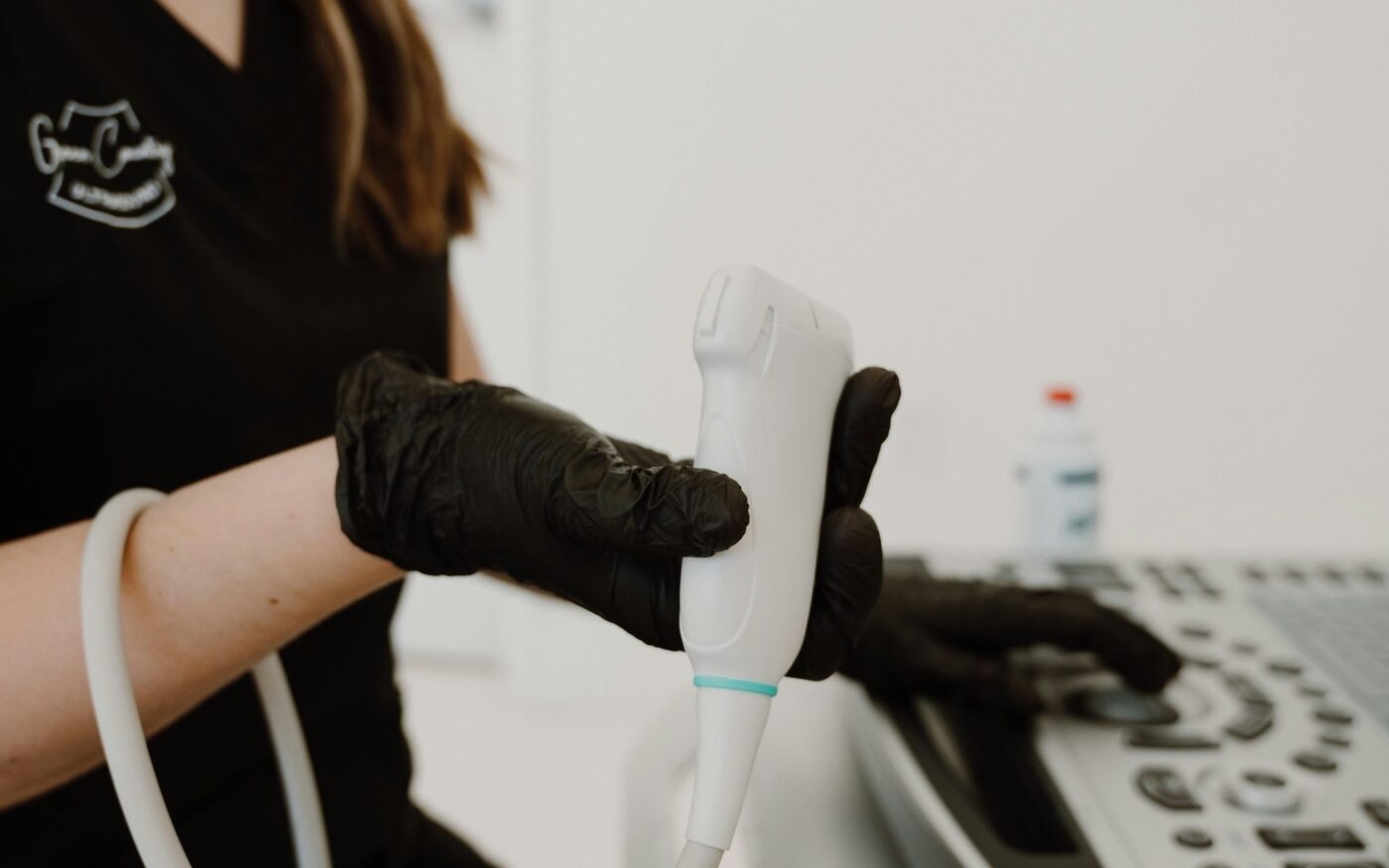 Echoscopist houdt een echokop vast tijdens een onderzoek